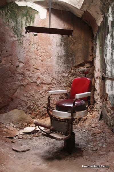 A barber's chair sits alone in a crumbling room at Eastern State Penitentiary in Philadelphia, Pennsylvania.