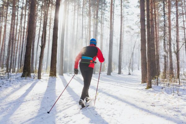 Man cross country skiing through the woods
