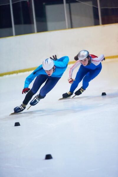 Two people speed skating around a track