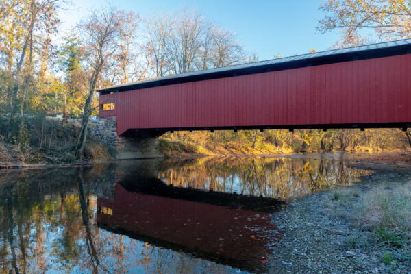 A side view of Ramp Covered Bridge with a stream running below it.