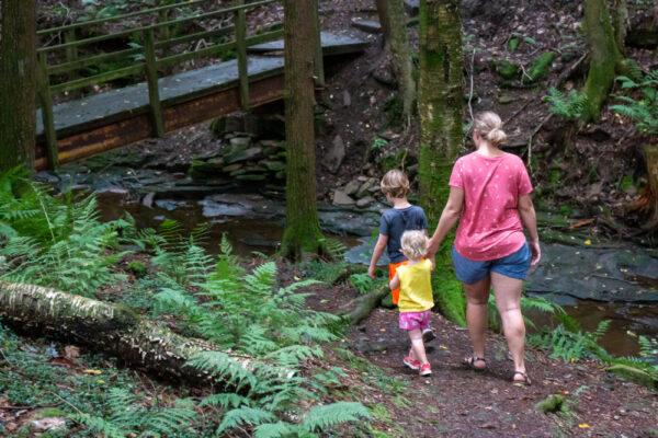 Family hiking the Falling Run Nature Trail in Goddard State Park.