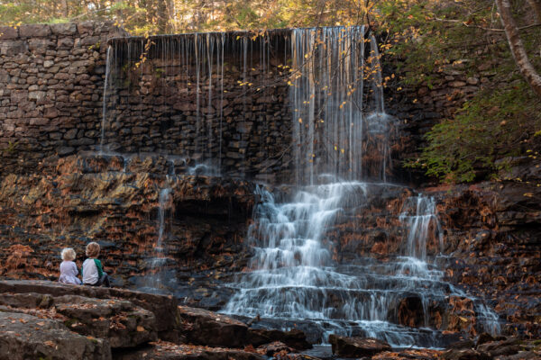 Kids sitting at a waterfall on the Shades of Death Trail at Hickory Run State Park in the Poconos of Pennsylvania