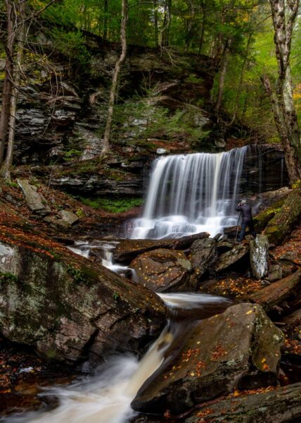 Man photographing a waterfall at Ricketts Glen State Park