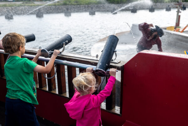 Kids shooting water cannons at a pirate in the Scallywags Cruise in Erie PA