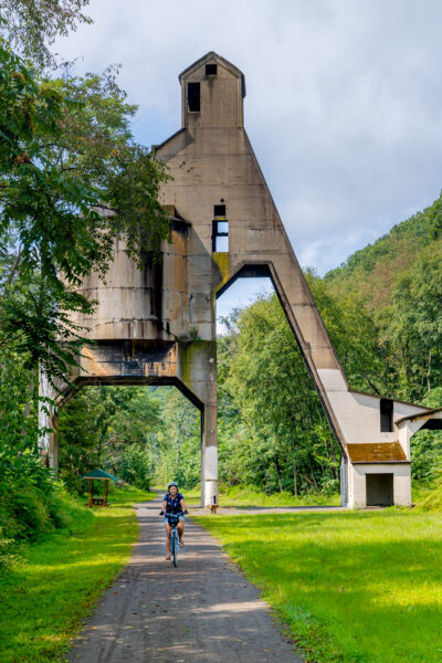 Woman riding a bike under a coaling tower on the Armstrong Rail Trail in Pennsylvania's Armstrong County