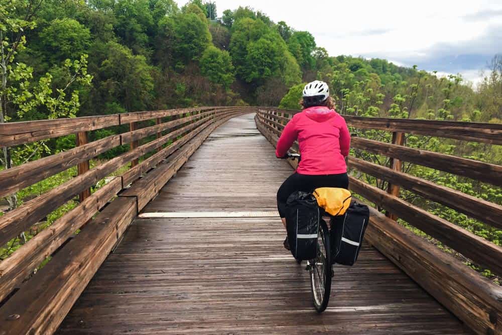 Woman biking over a bridge on a rail trail in Pennsylvania