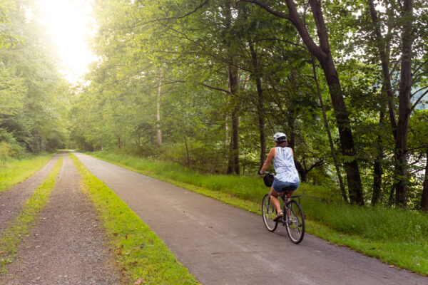 Woman biking on the Samuel Justus Recreation Trail at sunset