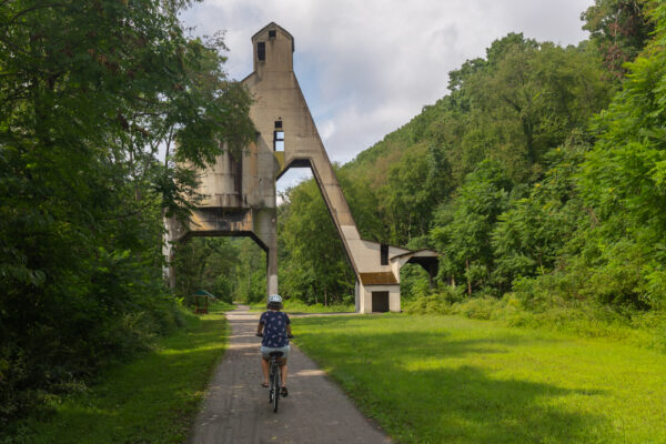 Woman biking the Armstrong Trail at the Coaling Tower Ruins