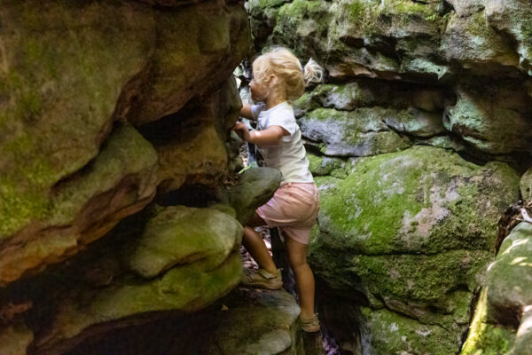 Child climbing rock at Panther Rocks in Clearfield County Pennsylvania