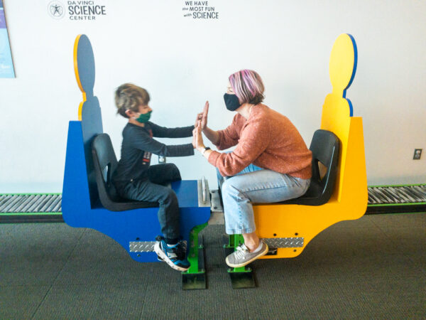 Two people on the Newton Chairs at the Da Vinci Science Center in Allentown Pennsylvania