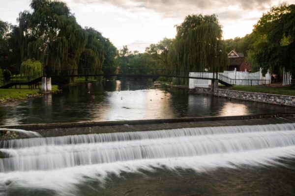 Dam waterfall and swinging bridge in PA's Talleyrand Park in Bellefonte