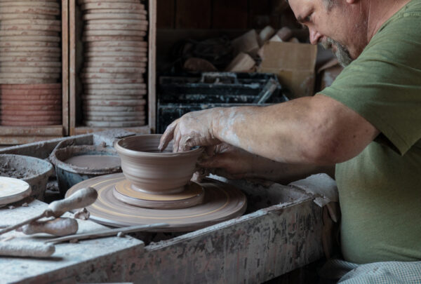 An artisan works in the pottery shop at Old Bedford Village.
