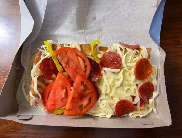 Two cuts of pizza with different toppings from Beto's Pizza in Beechview