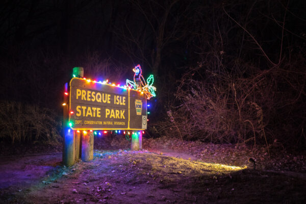 Entrance sign at Presque Isle State Park lit for the Christmas light display.