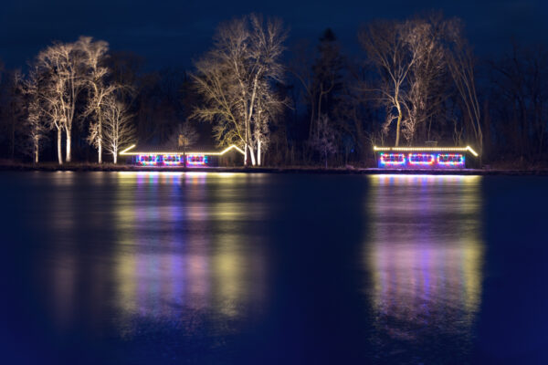 Lit buildings reflecting in a pond at Presque Isle Christmas lights in Erie PA