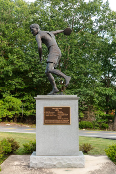 Statue of Jim Thorpe throwing a discus atop a stone pedestal at Jim Thorpe's grave in Pennsylvania