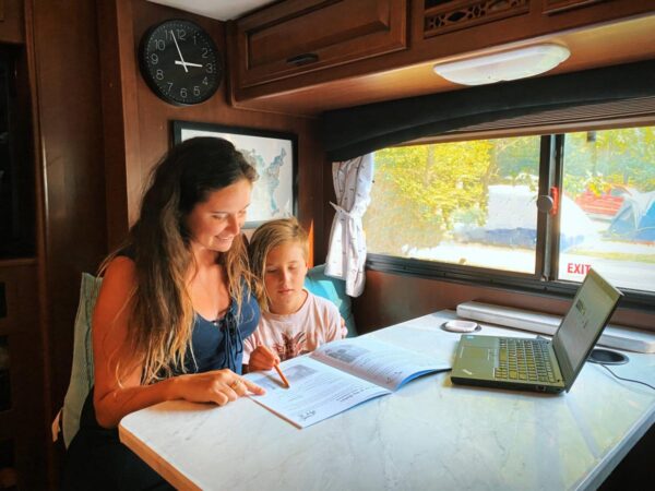 Woman and child at a table inside an RV