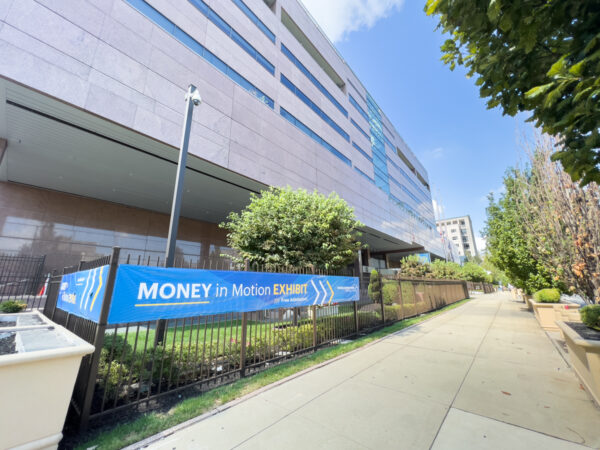 A blue sign on exterior of the Federal Reserve Bank of Philadelphia in Old City Philly points the way to the Money in Motion Exhibit.