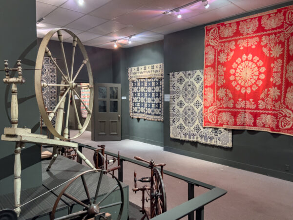 A loom and woven coverlets on display at the National Museum of the American Coverlet in the Alleghenies.