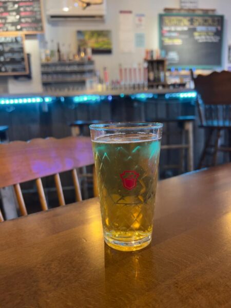 A glass of cider sits on a table at Ploughman Ciders in Gettysburg Pennsylvania