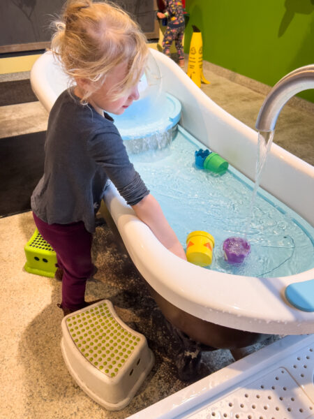 Girl plays in a water table at the Carnegie Science Center in Pittsburgh, Pennsylvania