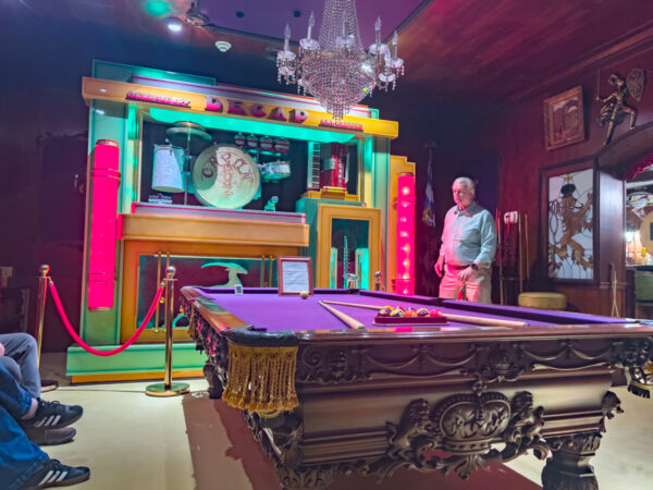 A man stands by a pool table next to an antique music box at the Bayernhof Museum near Pittsburgh Pennsylvania