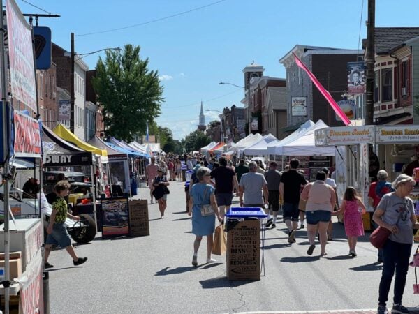 People walk down a street lined with tents at Jubilee Day in Mechnaicsburg PA