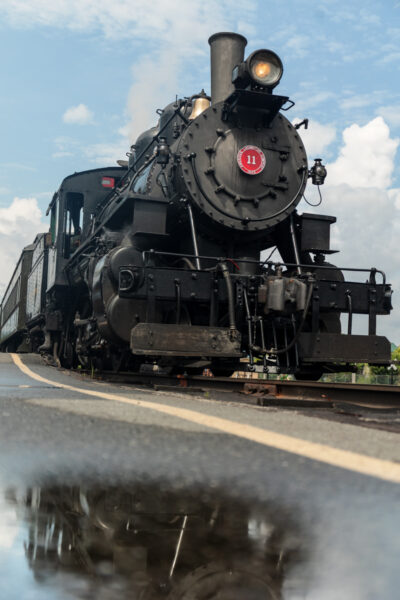 A steam engine with reflections in the water at the Everett Railroad in Hollidaysburg Pennsylvania