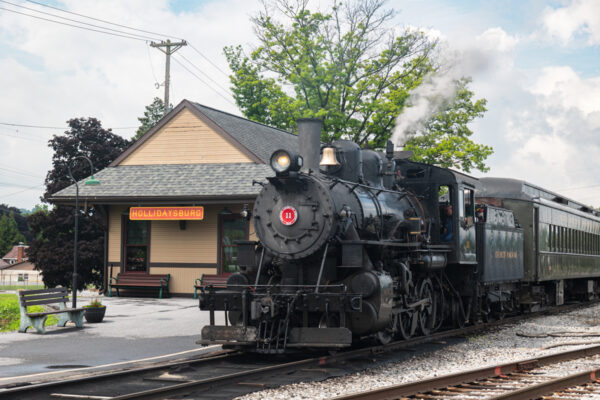 A steam engine sits next to a train station at the Everett Railroad in Hollidaysburg, PA