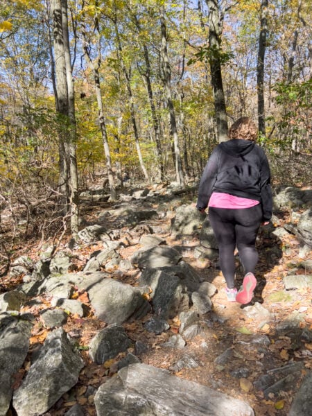 Woman hiking the rock strewn Lookout Trail at Hawk Mountain Sanctuary in Berks County Pennsylvania