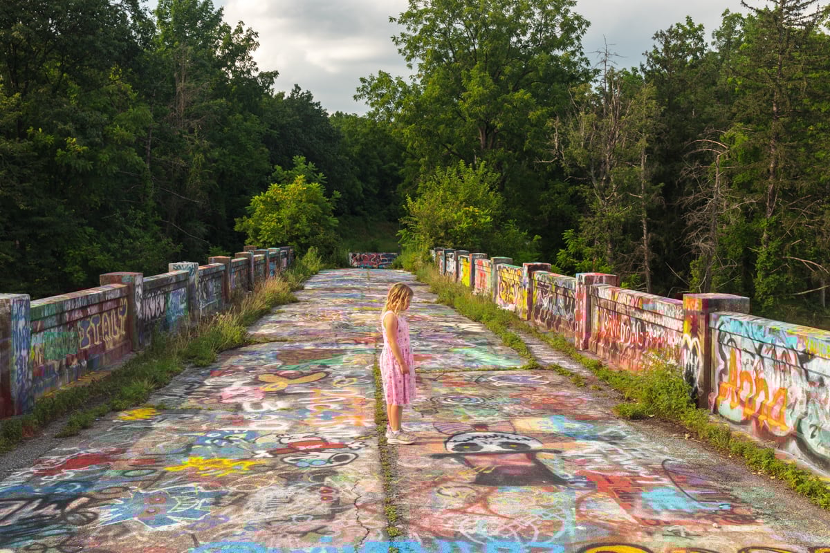 Young girl in a pink dress standing on Graffiti Bridge in Berks County PA