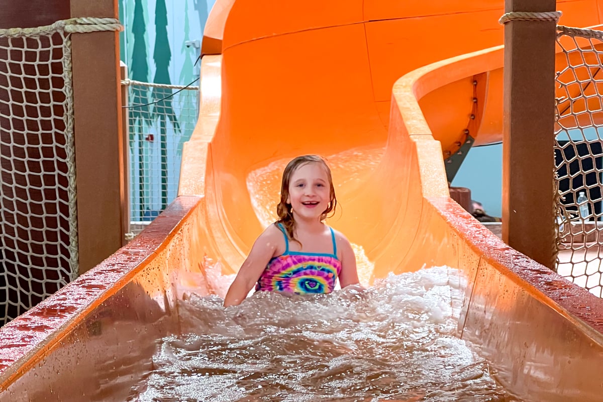 Child at the end of an orange waterslide at Great Wolf Lodge in the Poconos of Pennsylvania