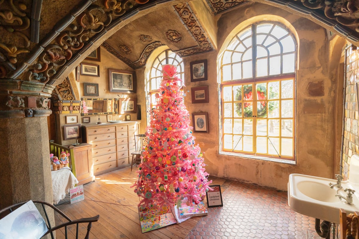 A pink Christmas tree on display in front of windows at Holidays at Fonthill Castle in Doylestown PA