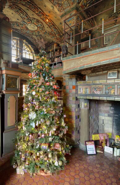 Christmas tree in front of a fireplace as seen during Holidays at Fonthill Castle in Bucks County PA
