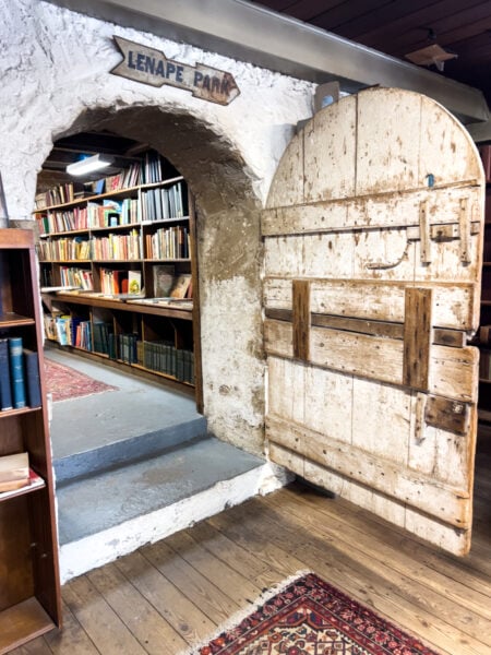 Wooden door open with a stone wall and books at Baldwin's Book Barn in Chester County, PA