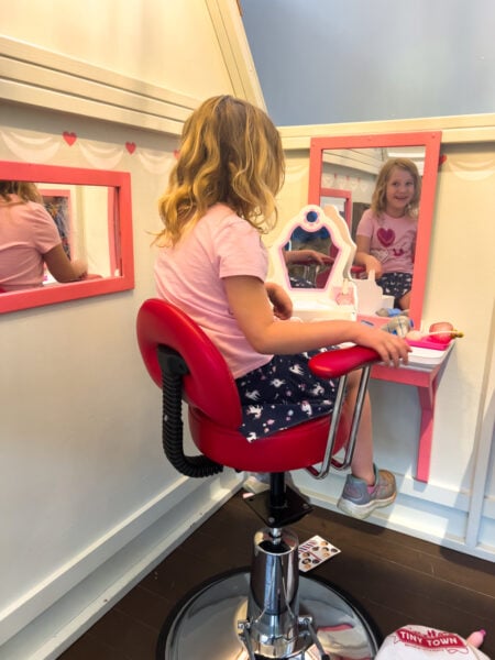 Girl sitting in a chair at the beauty salon play space at Tiny Town in Lancaster County Pennsylvania