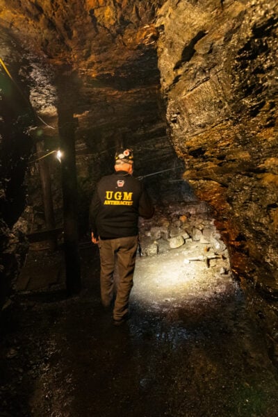 Volunteer with a flashlight walking into Brooks Mine in Scranton PA