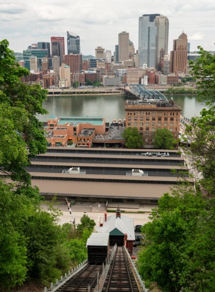 Looking down on the tracks of the Monongahela Incline with the skyline of Pittsburgh in the background.