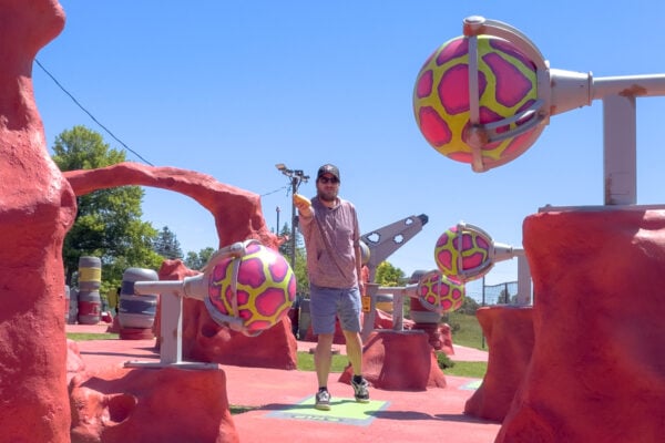 Man throwing a bag while surrounded by alien decor at Cornhole Golf in Mars, PA.
