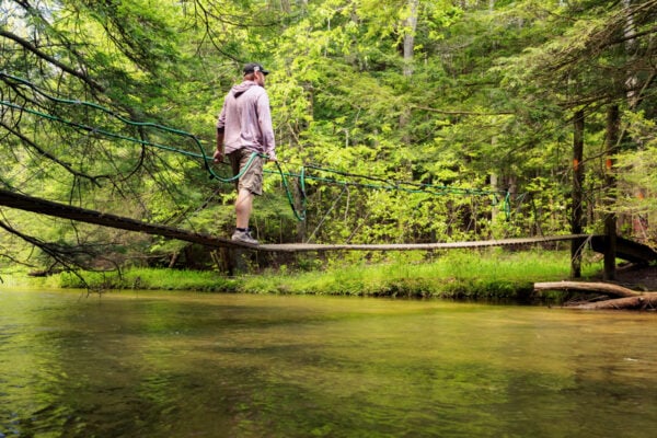 Man crossing the John P Saylor Trail Swinging Bridge in Gallitzin State Forest in PA