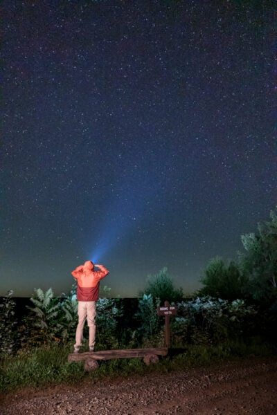 Man with a flashlight standing under the stars at Boone Run Vista in Potter County, PA
